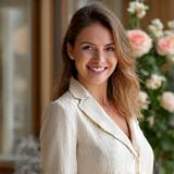 Portrait d'Élodie Dubois, Maître Fleuriste à Fleurisage Éclat, souriante parmi des roses anciennes.